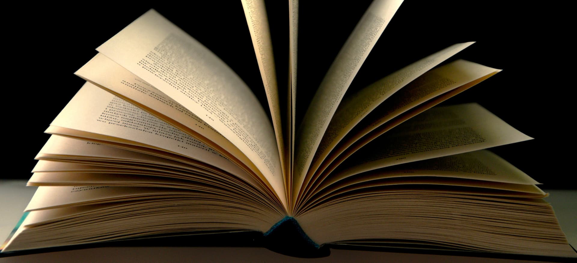 a book being opened on a table, the pages are flipping over. 