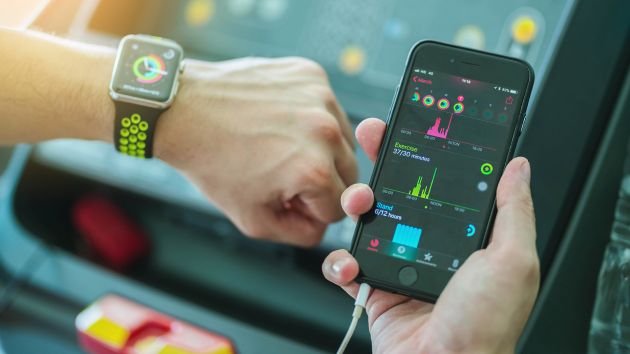 Person compares data on smartphone and smartwatch