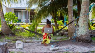 Young islander woman using a laptop in a hammock