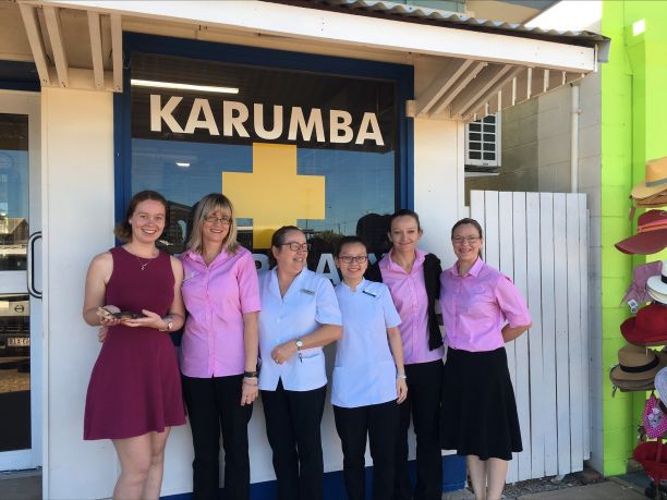 Group of six women in front of sign for Karumba pharmacy