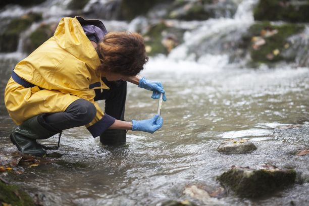 student taking measurements of a stream. 