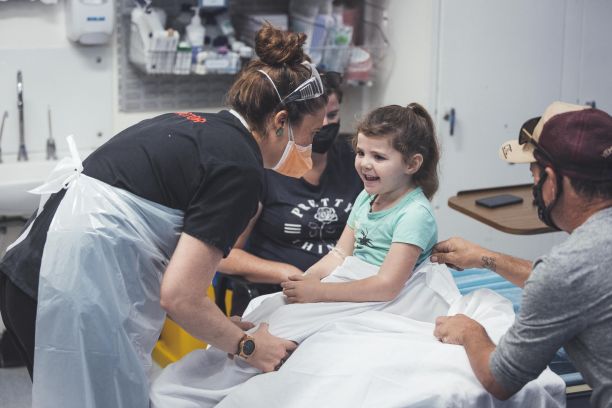 female doctor in mask talking to young patient