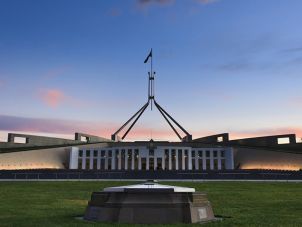 The front of Parliament House with the evening sky behind it. 