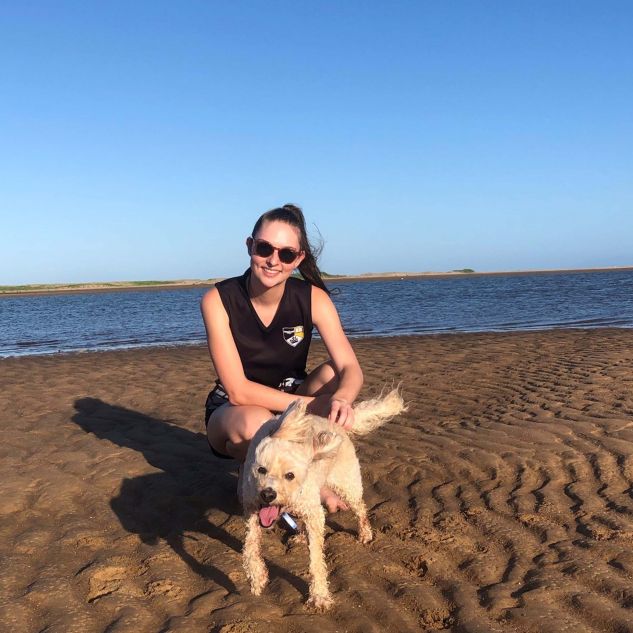 Holly Mason with her dog on the beach in Townsville. 