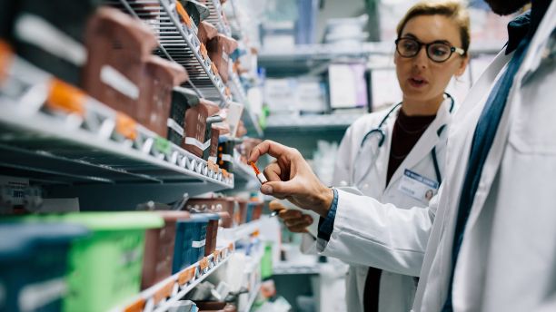 Two hospital pharmacists checking drug stocks