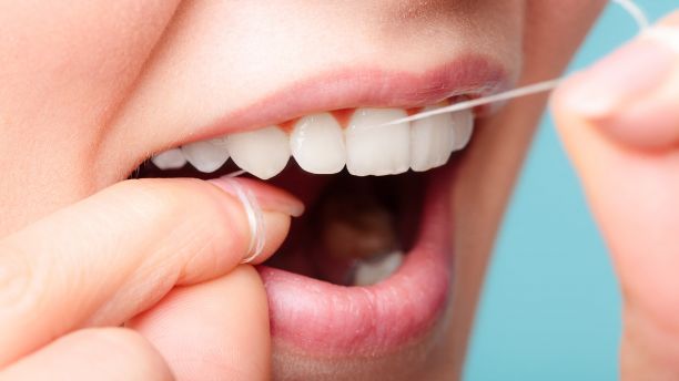 Closeup of a woman flossing her teeth