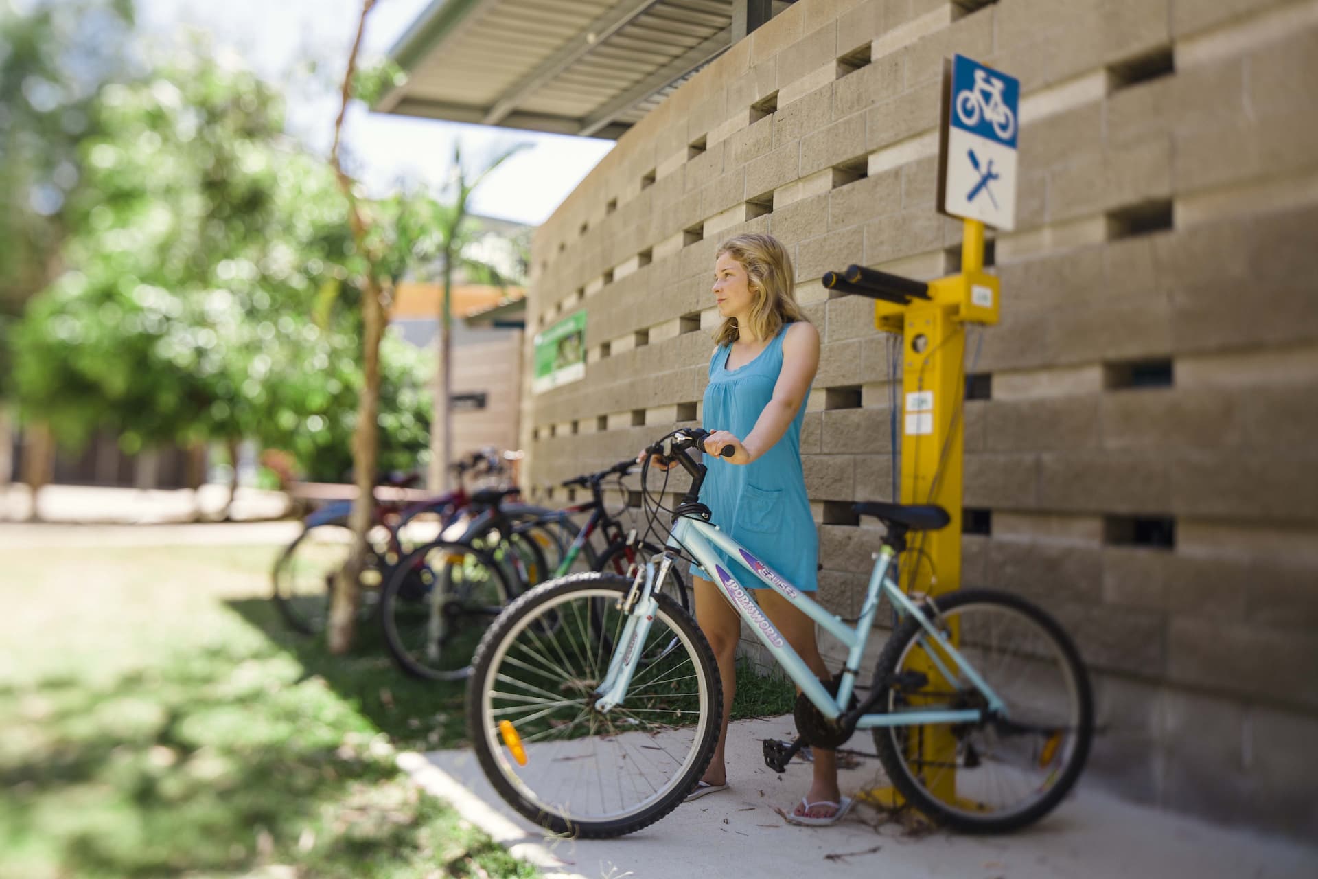 Student standing with Mountain Bike infront of the JCU Bike workstation. 