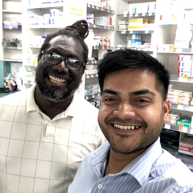 Two pharmacists smiling in shop