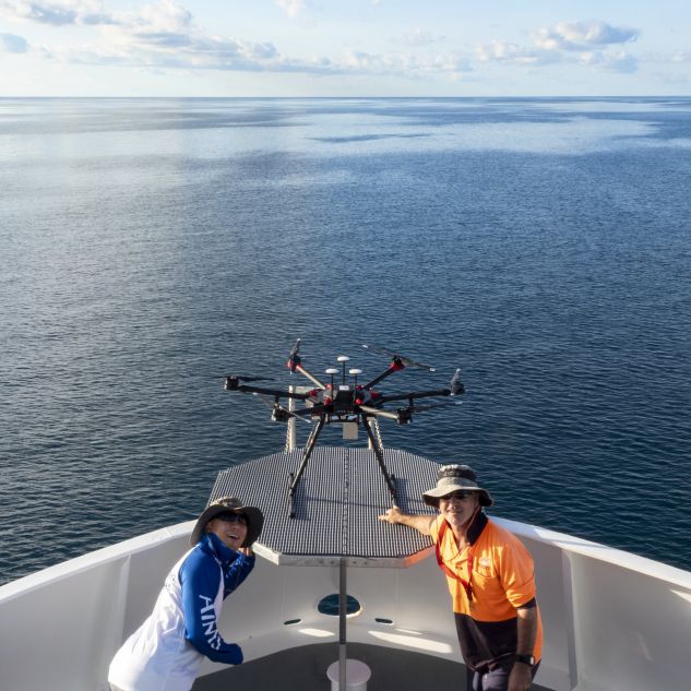  AIMS chief pilot Joe Gioffre and engineer Dr Jon Kok posing on a boat in front of the AIMS hyperspectral drone system. 