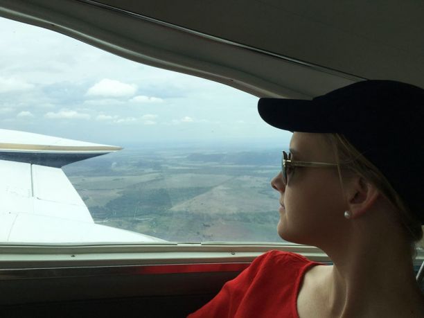 Young woman looking out of light plane window