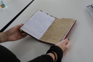 A student's hands holding their zine open. 