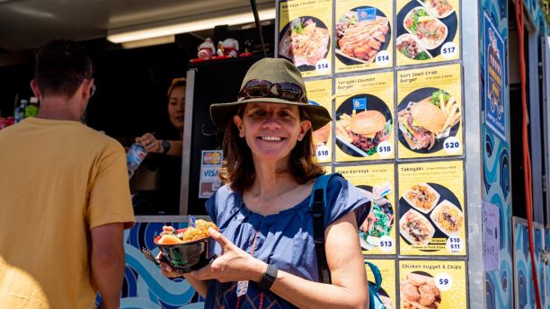 Plastic Free Foundation founder Rebecca Prince-Ruiz smiling and holding takeaway food in a reusable bowl. 
