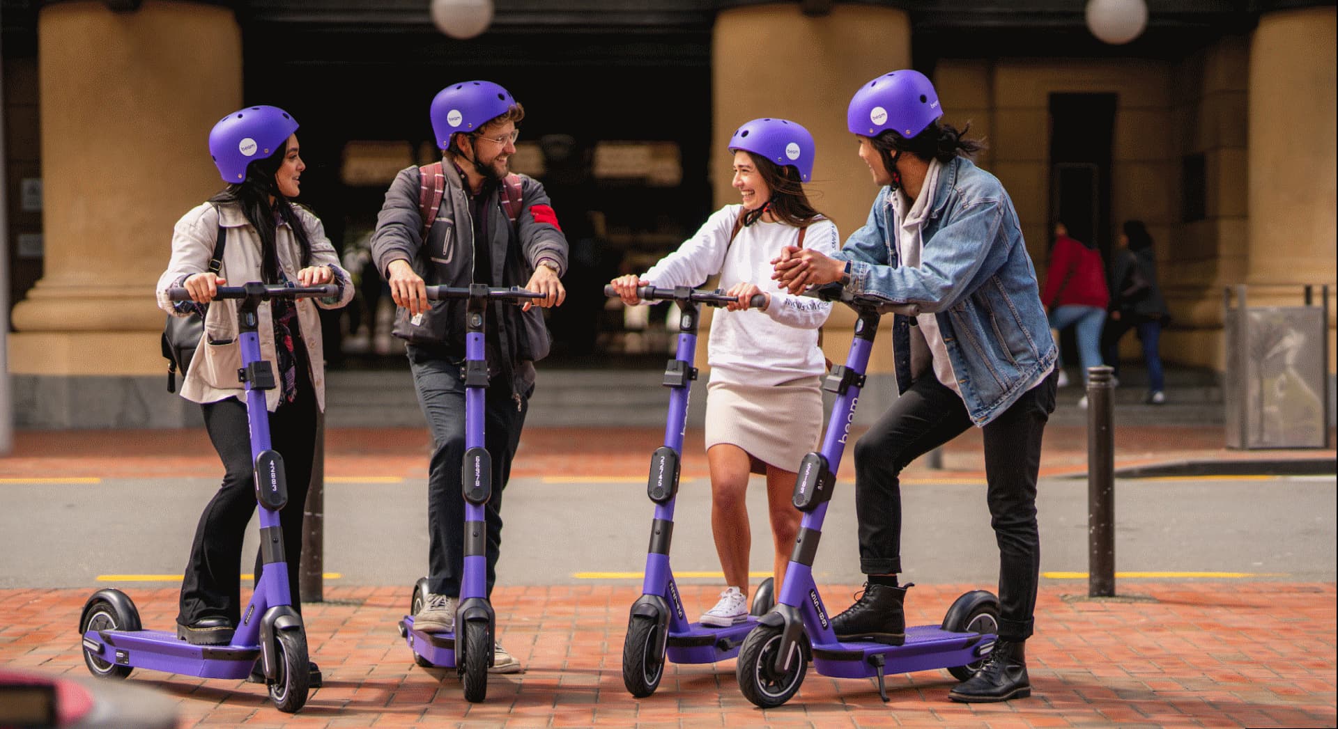 Group of people riding rentable electric scooters. 