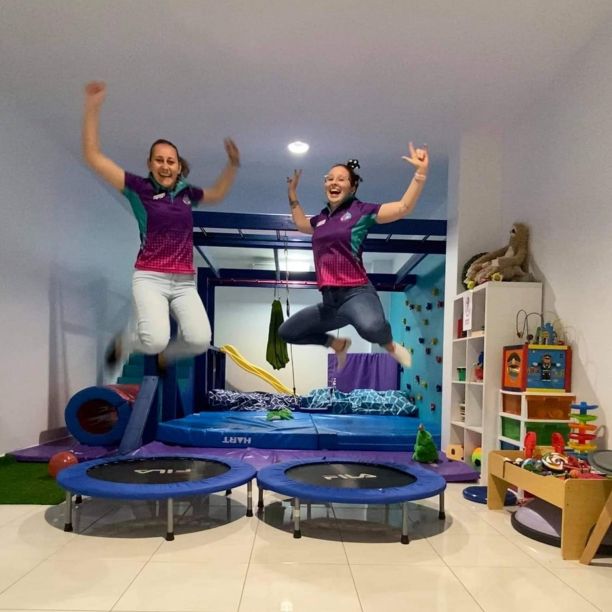 Two people jumping on small trampolines smiling and with their arms in the air surrounded by occupational therapy resources. 
