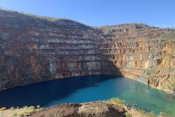 A view of the layered earth wall and pool of water at the Mary Kathleen open-cut mine. 