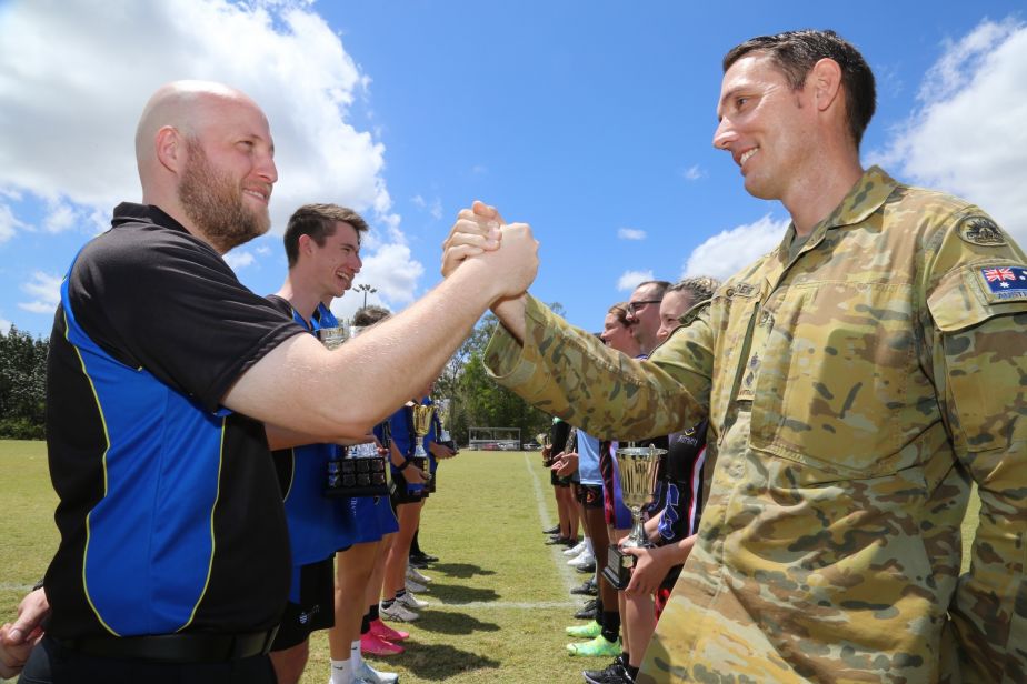 JCU Student Association Sport and Recreation manager Jason Conn and Deputy Commander of the Army’s 3rd Brigade, Lt Col Ken Golder face off with players from the Uni and Army teams ahead of this Friday’s Uni vs Army Games.