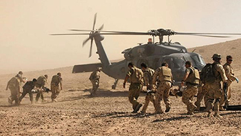Soldiers infront of helicopter. 