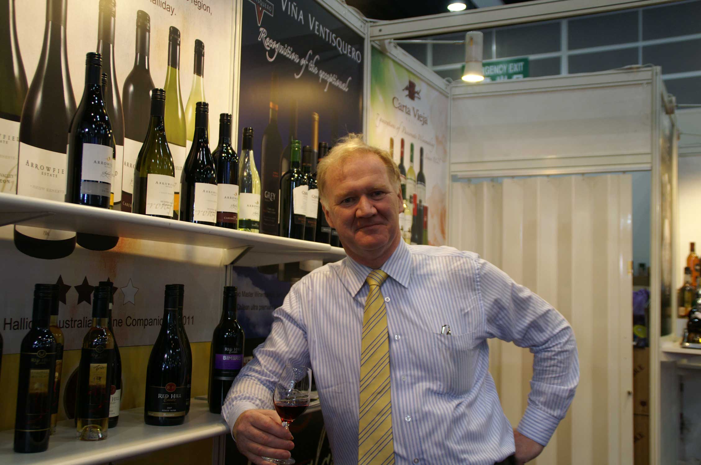 Ken Waldron posing in front of wine shelf