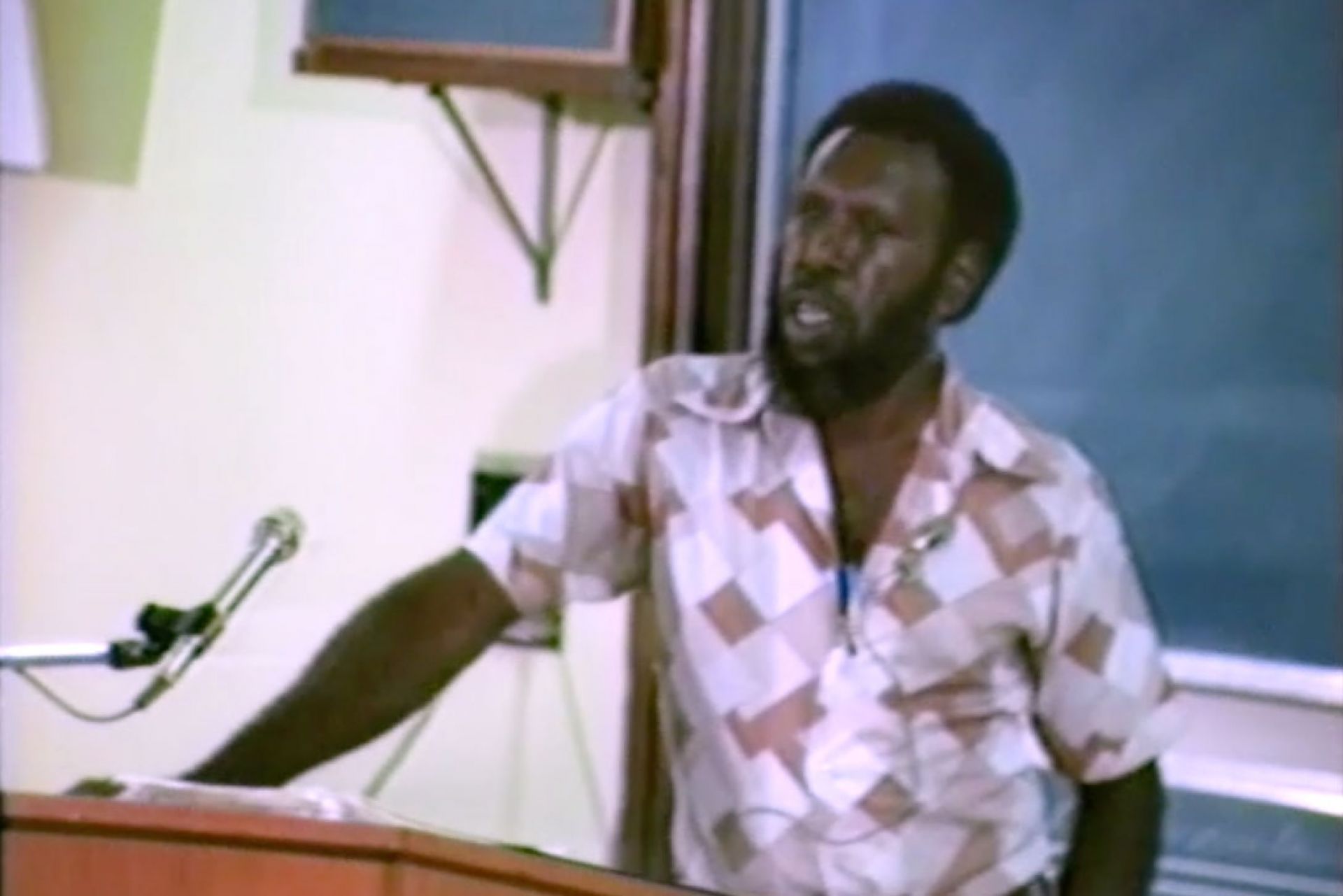 Koiki Mabo stands at a lectern, talking