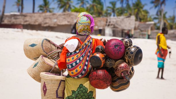 African woman with a baby selling woven items