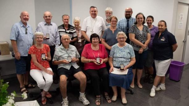 Group of Townsville Catholic Archives volunteers with Townsville Diocese Bishop Father Timothy Harris in the centre and JCU Phd alumni Wayne Bradshaw fourth from the right at the back. 