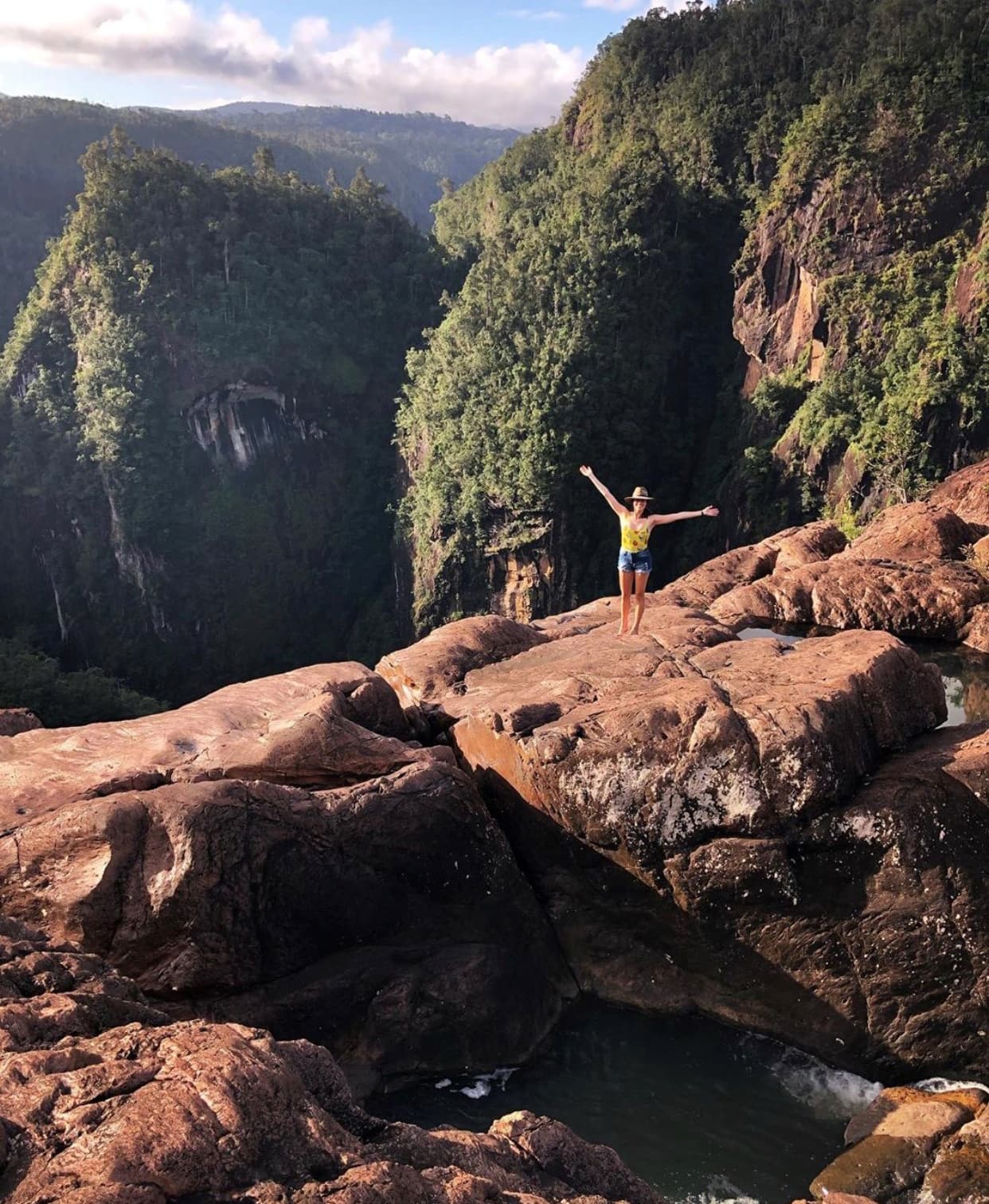 Carolyn Reimann on a cliff edge in the tropics