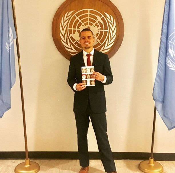 Jesse wearing a suit and tie, smiling for a photo at the United Nations Forum in New York.