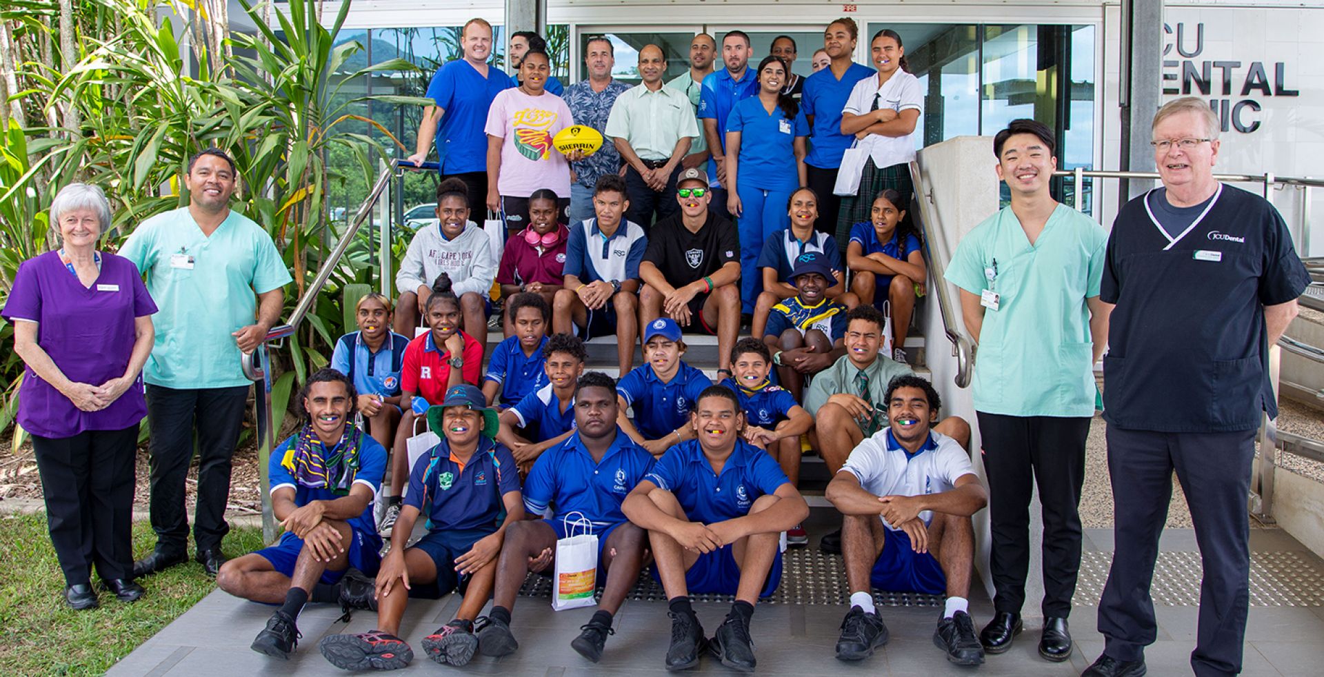 students from Cape York AFL House at the entrance to JCU's Dental Clinic, with Clinic staff and Dentistry students.  