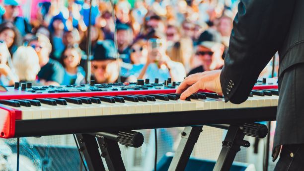Musician playing keyboard in front of crowd
