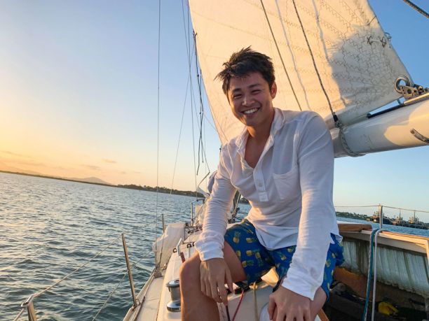 Young man on yacht at sunset