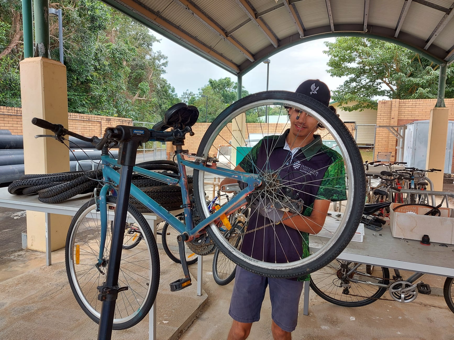 Student mechanic working on green fleet bicycle