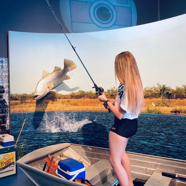 Young woman catching a fish in a display