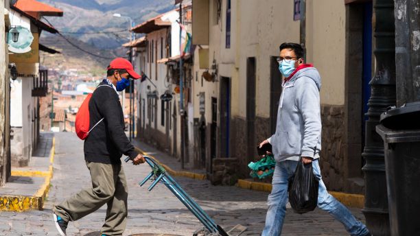 Two men in Latin America wearing masks. 