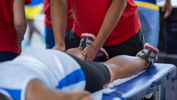 A physiotherapist massages an athlete's legs