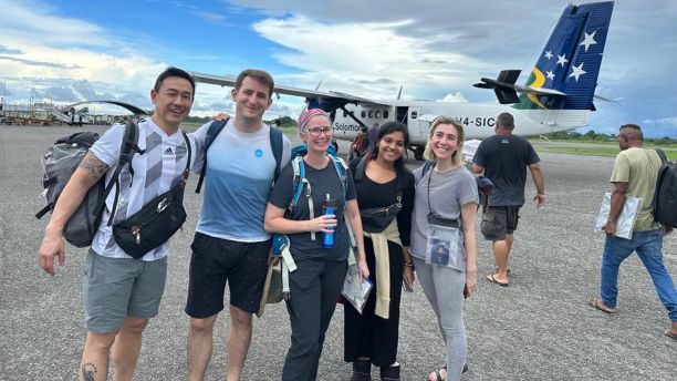 Sowmya Bolla and colleagues stand in front of a small plane.