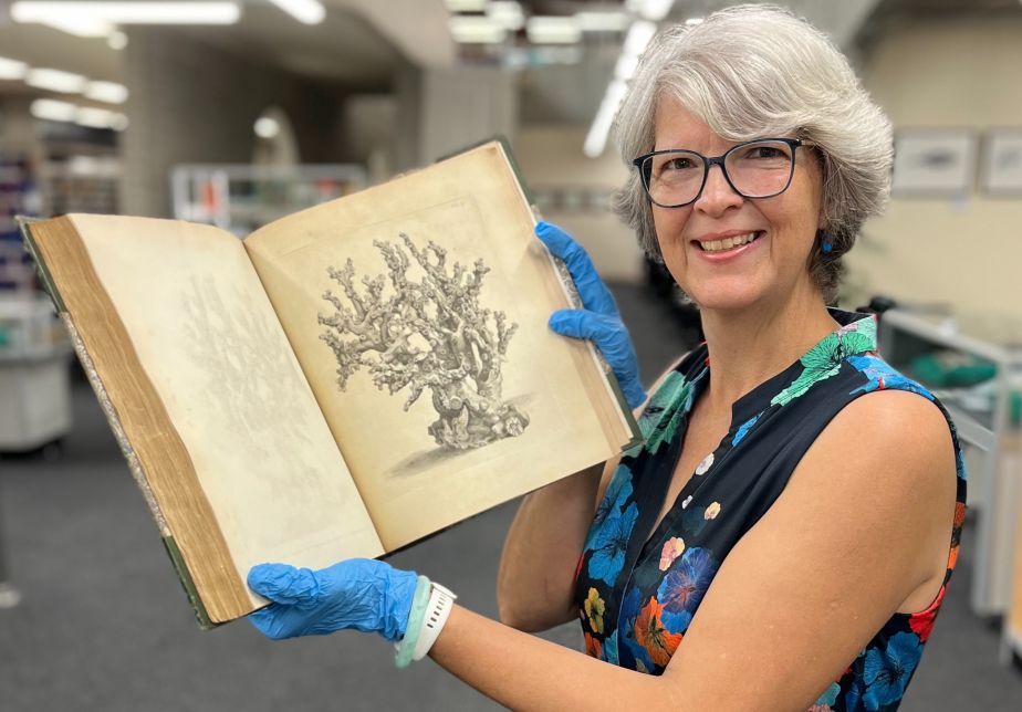 JCU Library Special Collections Manager Bronwyn McBurnie holds one of the books from the collection
