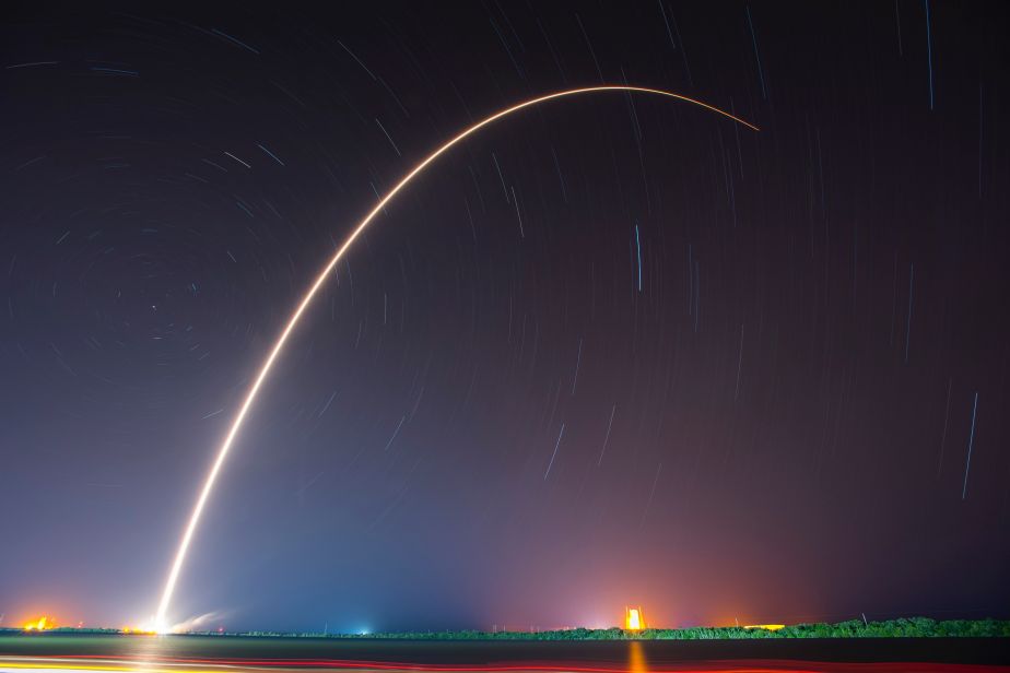 A streak of fire in a night sky as a rocket takes off. 