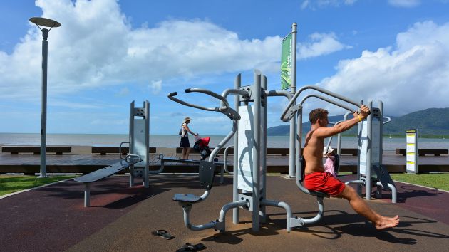 Man exercising on outdoor gym equipment