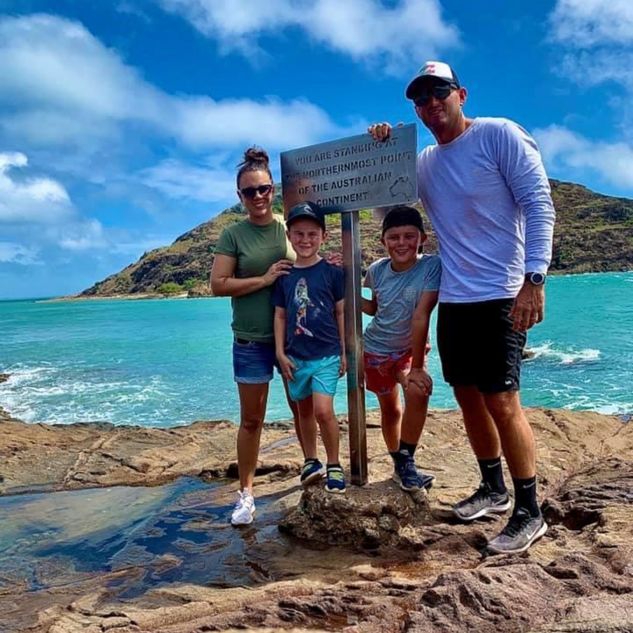 Family in front of sign saying you are standing in the northernmost part of the Australian continent