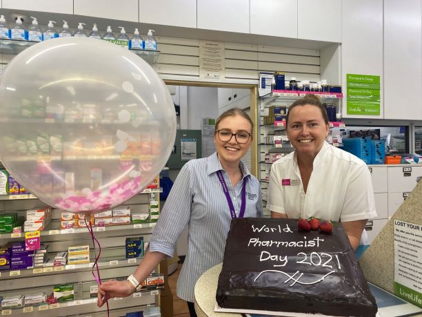two women with World Pharmacist Day 2021 cake
