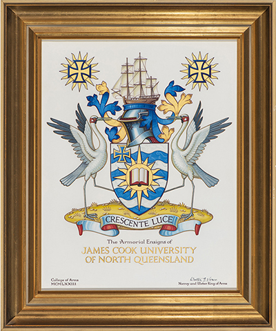 The JCU Coat of Arms featuring a blue and gold shield, a ship, two Brolgas, and the motto crescent luce