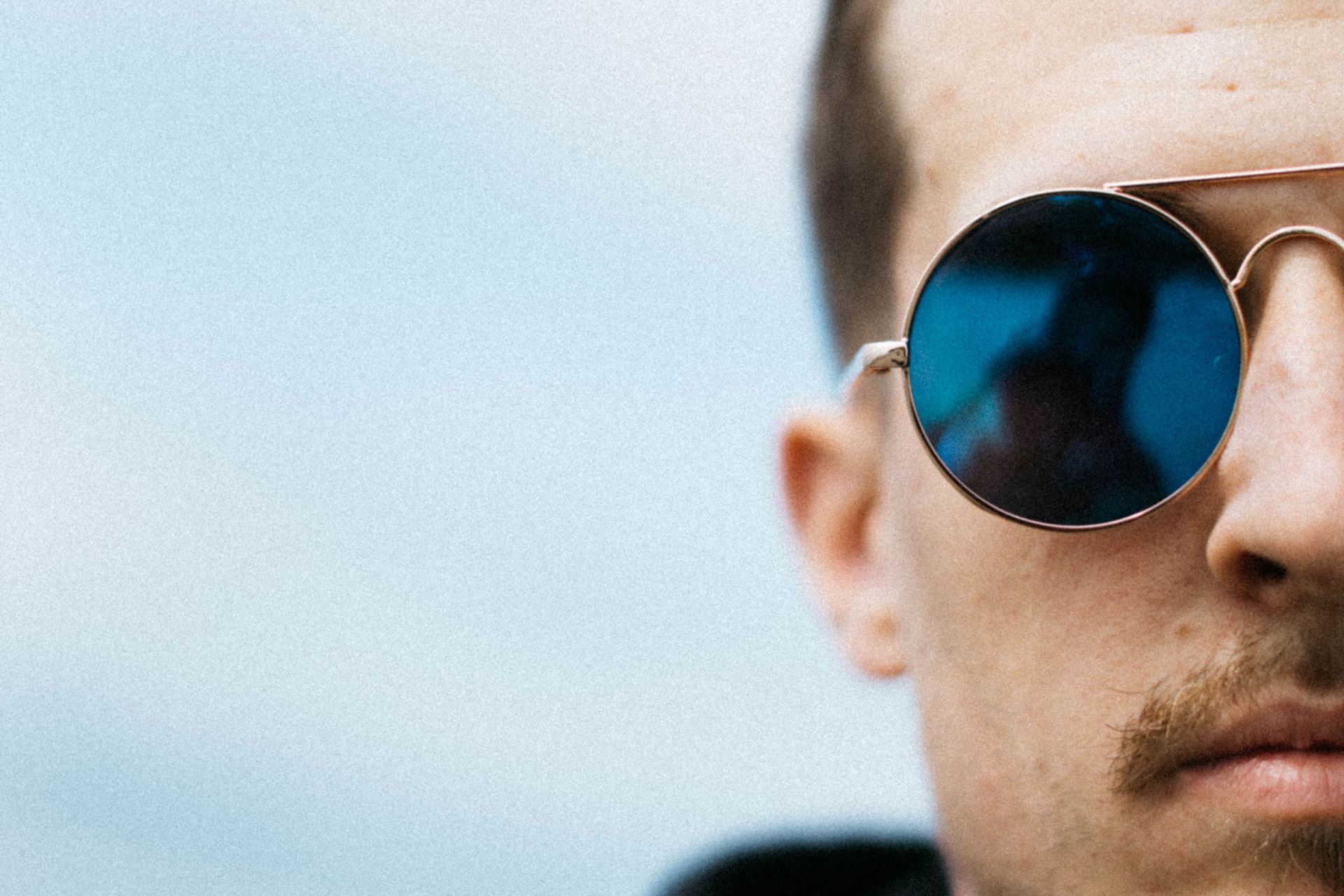 Close up of half a man's face. he is wearing sunglasses