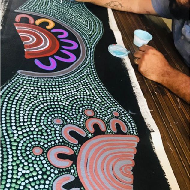 Wayne Martin painting the Indigenous artwork for the plinth