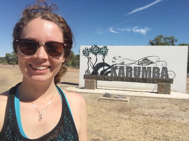 Woman in front of Karumba sign