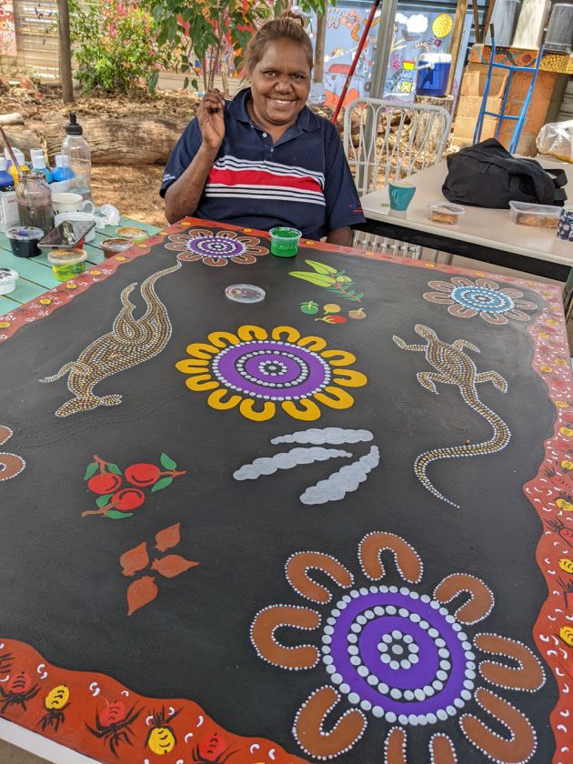 Aboriginal woman painting colourful artwork