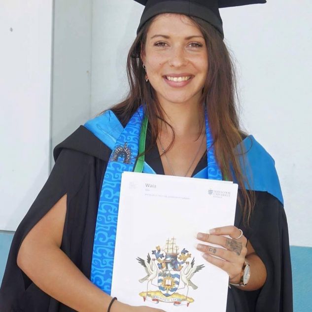young female uni graduate in cap and gown holding certificate