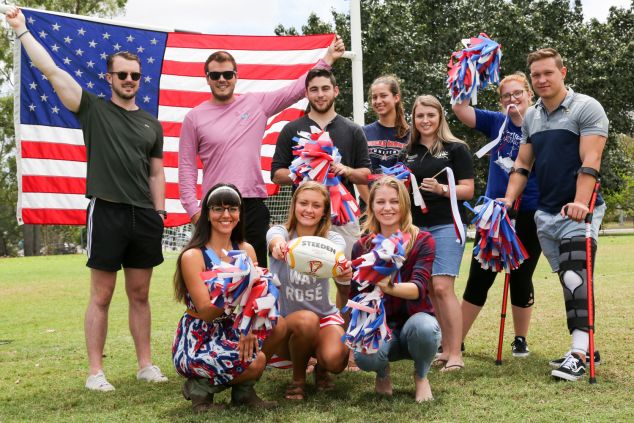 JCU students holding pompoms and a USA flag.