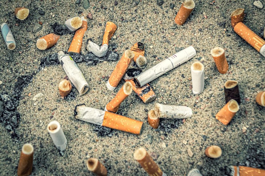 Pile of cigarette butts discarded on sand