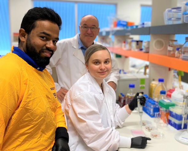 Three members of the JCU MARL lab smililng and sitting at the lab bench. 
