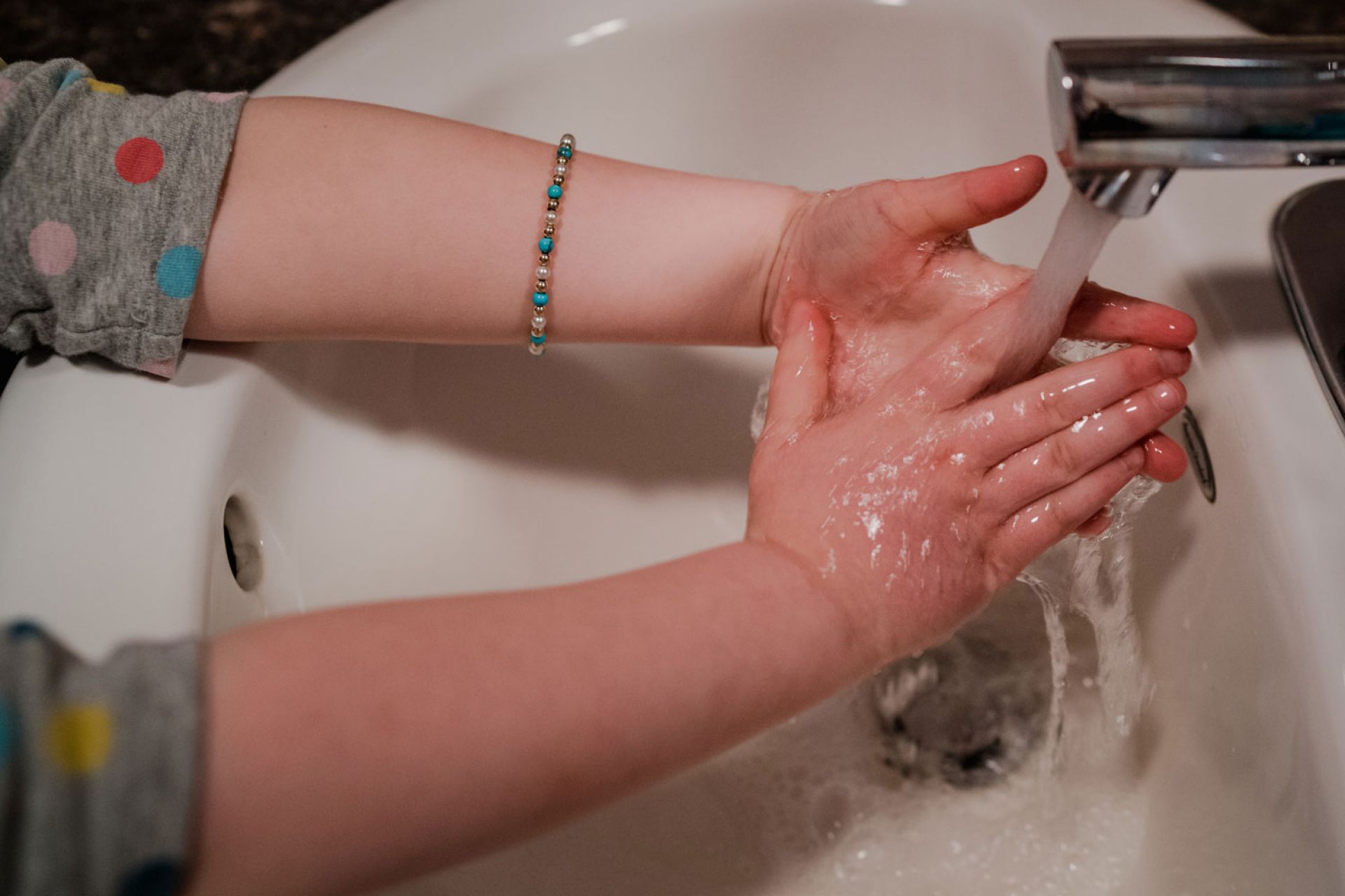 Close up of hands being washed in a basin